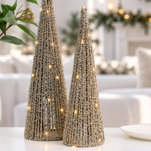 Small gold beaded LED Christmas tree beside the matching larger size on a white table