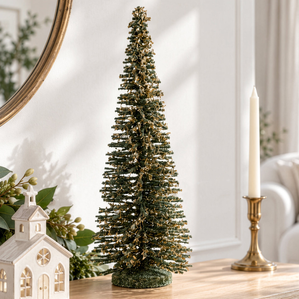 Large green Christmas tree decoration with gold dusting detail displayed on a table