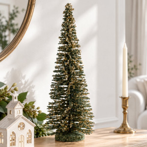 Large green Christmas tree decoration with gold dusting detail displayed on a table