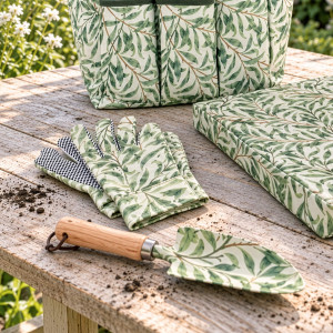 Greenhaven trowel and gloves on a timber garden table beside the matching bag and knee pad