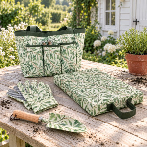 Greenhaven trowel and gloves displayed with the matching bag and knee pad on a table in a cottage garden