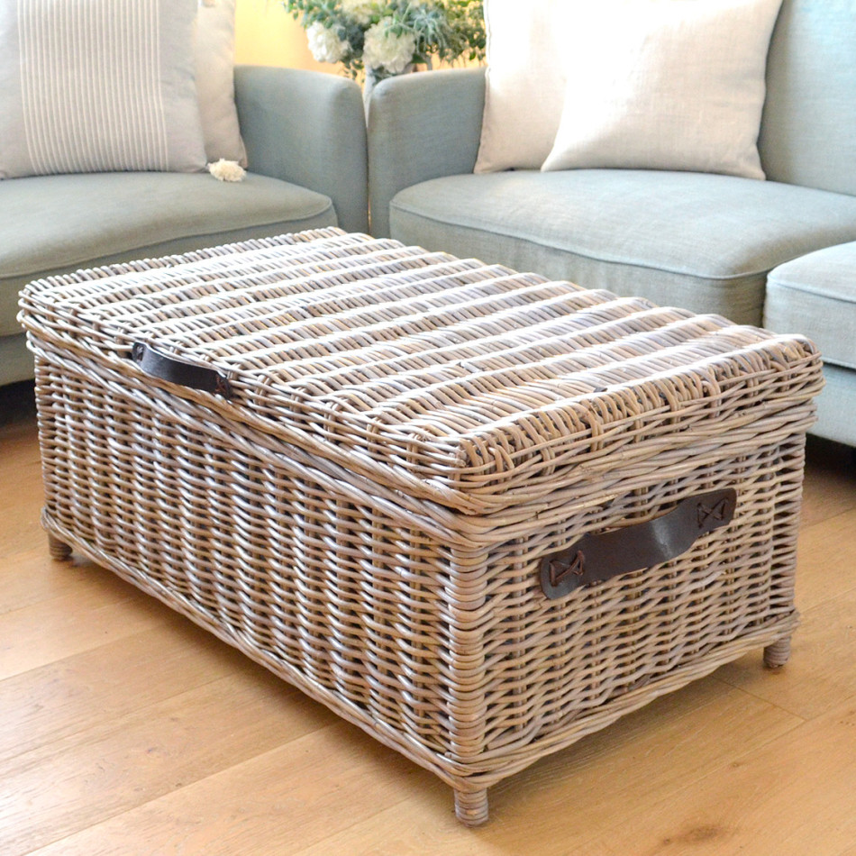 Hartley antique grey rattan trunk coffee table with brown leather handles beside a sofa