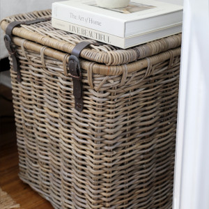 Close view of woven rattan trunk lid and two brown leather buckle straps