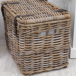 Angled view of the woven rattan trunk showing its rectangular shape and side panel