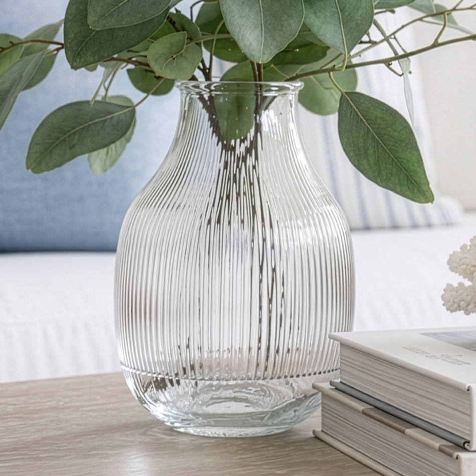 Close-up of the clear ribbed glass vase filled with eucalyptus foliage