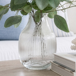 Close-up of the clear ribbed glass vase filled with eucalyptus foliage