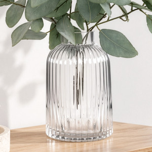 Close-up of the clear ribbed glass vase filled with eucalyptus foliage