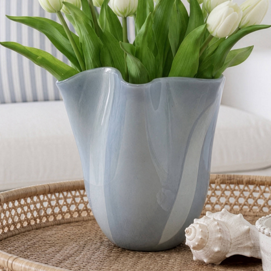 Close-up of the sea grey glass vase with a rippled form, waved rim and white tulips