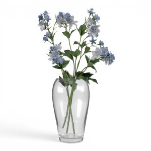 Tall clear glass vase arranged with blue flowers and green foliage