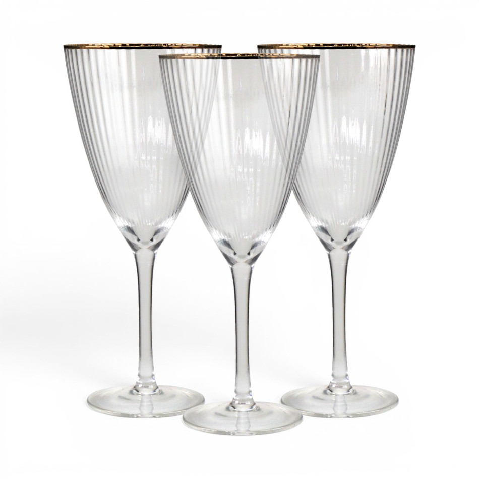 Three clear ribbed wine glasses with gold-coloured rims and tall stems against a white background